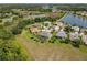 Aerial view of a neighborhood showcasing homes and ponds, lush greenery, and picturesque scenery under a clear sky at 27027 Old English Ct, Leesburg, FL 34748