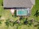 Aerial view of a screened-in pool surrounded by mature trees and manicured landscaping at 27027 Old English Ct, Leesburg, FL 34748