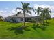 Spacious backyard with lush lawn, mature trees, and screened-in pool create a private oasis at 27027 Old English Ct, Leesburg, FL 34748