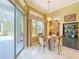 Bright breakfast nook with pool view, features a glass-topped table with chairs and a storage cabinet at 27027 Old English Ct, Leesburg, FL 34748