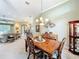 Elegant dining room featuring a wood table, chandelier, and seamless flow into the living space at 27027 Old English Ct, Leesburg, FL 34748