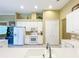 Bright kitchen with white cabinets and stainless steel faucet with ample storage space at 27027 Old English Ct, Leesburg, FL 34748