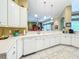 Bright kitchen view featuring white cabinets with a view to the living room at 27027 Old English Ct, Leesburg, FL 34748