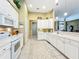 Bright kitchen featuring white cabinetry, countertops, and tile flooring at 27027 Old English Ct, Leesburg, FL 34748