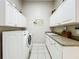 Laundry room includes washer, dryer, sink, and storage at 27027 Old English Ct, Leesburg, FL 34748