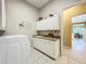 Laundry room with extra storage, a sink, and cabinets at 27027 Old English Ct, Leesburg, FL 34748