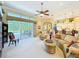Bright living room with a ceiling fan, large sliding glass doors to the outdoor area, and comfortable seating at 27027 Old English Ct, Leesburg, FL 34748