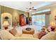 Comfortable living room featuring a striped accent wall, ceiling fan, and sliding glass doors to the pool area at 27027 Old English Ct, Leesburg, FL 34748