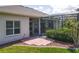 Enclosed patio with tiled floor and outdoor seating visible through sliding glass doors on a sunny day at 27027 Old English Ct, Leesburg, FL 34748