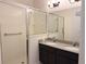 Bathroom featuring a large glass shower with a shower seat, double sinks and a vanity with dark wood at 2721 Picasso Ct, Kissimmee, FL 34743