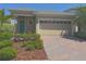 Charming single-story home featuring a brick driveway, lush landscaping, and a two-car garage at 2721 Picasso Ct, Kissimmee, FL 34743