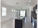 Open floorplan featuring kitchen with island, stainless appliances, and large windows for natural light at 2721 Picasso Ct, Kissimmee, FL 34743