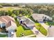 Aerial view of a home featuring a well-maintained lawn and landscaping with a lake and wooded area nearby at 27510 Discover Ct, Leesburg, FL 34748