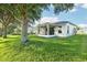 Exterior shot of an enclosed sunroom and backyard with mature trees at 27510 Discover Ct, Leesburg, FL 34748