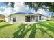 Exterior shot of an enclosed sunroom with ceiling fan and spacious yard at 27510 Discover Ct, Leesburg, FL 34748