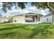 Backyard view of a home featuring an enclosed sunroom with ceiling fan at 27510 Discover Ct, Leesburg, FL 34748
