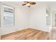 Bedroom featuring wood floors, a ceiling fan, and a large window at 27510 Discover Ct, Leesburg, FL 34748