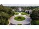 Aerial view of the clubhouse with clock tower featuring lush landscaping, sidewalks, and palm trees at 27510 Discover Ct, Leesburg, FL 34748