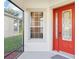 Inviting red front door with decorative glass and a screened porch at 27510 Discover Ct, Leesburg, FL 34748