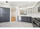 Open kitchen with modern gray cabinetry, stainless steel appliances, and plank flooring at 27510 Discover Ct, Leesburg, FL 34748