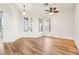 Spacious living room featuring wood floors, a ceiling fan, and a decorative glass front door at 27510 Discover Ct, Leesburg, FL 34748
