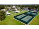 The tennis courts are adjacent to the clubhouse and are surrounded by lush green grass at 27510 Discover Ct, Leesburg, FL 34748