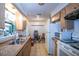 Functional kitchen with wooden cabinets, laminate countertops, and a view to the dining area at 30011 County Road 437, Sorrento, FL 32776