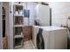 Practical laundry area with a washer, dryer, shelving, and tile flooring at 30011 County Road 437, Sorrento, FL 32776