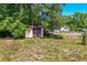 A small storage shed in the backyard, partially obscured by dense shrubbery at 30011 County Road 437, Sorrento, FL 32776