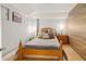 Bedroom features a cozy bed with soft pillows, bedside tables, and wood paneled accent wall at 306 N Clayton St, Mount Dora, FL 32757