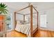 A beautifully staged bedroom with hardwood floors and a four-post bed, leading out to a patio at 306 N Clayton St, Mount Dora, FL 32757