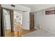 Bedroom showing tile flooring, a mirror, wooden wardrobe, and open doorway to the kitchen at 306 N Clayton St, Mount Dora, FL 32757