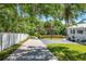 Long driveway leading to a white house with a well-kept lawn and mature trees at 306 N Clayton St, Mount Dora, FL 32757