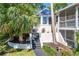 Unique home exterior showcases a striking turret feature, complemented by lush landscaping and inviting stairway at 306 N Clayton St, Mount Dora, FL 32757