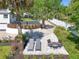 Charming patio featuring outdoor furniture, surrounded by lush tropical landscaping and a manicured lawn at 306 N Clayton St, Mount Dora, FL 32757