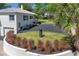 Two-story home featuring black asphalt driveway, lush lawn and curated garden bed at 306 N Clayton St, Mount Dora, FL 32757