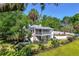 Spacious property boasts manicured lawns, mature trees, and an inviting two-story home with screened porches at 306 N Clayton St, Mount Dora, FL 32757