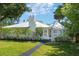 Charming one-story home featuring a metal roof, lush landscaping, and a well-manicured front lawn at 306 N Clayton St, Mount Dora, FL 32757