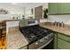 Close-up of a modern gas range and granite countertops in a well-lit kitchen space at 306 N Clayton St, Mount Dora, FL 32757