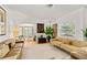 Inviting living room features hardwood floors, neutral sofas, and a sunlit bay window at 306 N Clayton St, Mount Dora, FL 32757