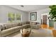 Bright living room boasts a comfortable sectional, decorative pillows, and stylish glass coffee table at 306 N Clayton St, Mount Dora, FL 32757