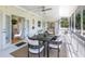 Screened porch features a ceiling fan and an outdoor dining table and chairs at 306 N Clayton St, Mount Dora, FL 32757