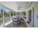 Covered, screened-in porch with table, chairs, and an artful, white tiger statue at 306 N Clayton St, Mount Dora, FL 32757