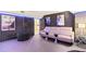 Home theater room featuring sound dampening panels, modern furniture, and movie poster decor at 306 N Clayton St, Mount Dora, FL 32757