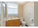 Standard bathroom with classic wood vanity, neutral walls and a toilet at 3075 Cr 431N, Lake Panasoffkee, FL 33538