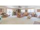 Bright living room with plush sofas, neutral carpet, lots of seating, and sunlit windows at 3075 Cr 431N, Lake Panasoffkee, FL 33538