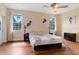 Comfortable bedroom with hardwood floors, ceiling fan, and natural light from two windows at 31728 Nutmeg Ave, Eustis, FL 32736