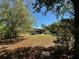 A wooden shelter sits in a yard, framed by trees, offering a rustic and natural view at 31728 Nutmeg Ave, Eustis, FL 32736