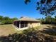 Backside view of the home featuring a tan stucco exterior and screened lanai at 31728 Nutmeg Ave, Eustis, FL 32736