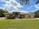 Charming one-story home featuring a well-manicured lawn and inviting arched entryway at 31728 Nutmeg Ave, Eustis, FL 32736